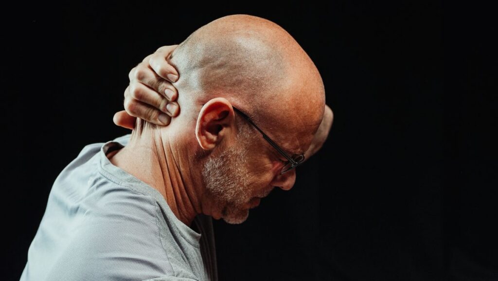 Person holding their neck depicting whiplash recovery timeline, evaluated at The Neural Connection clinic