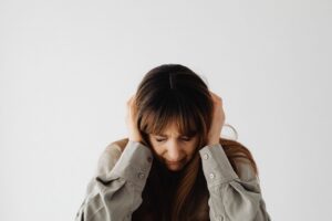 Person holding ear depicting tinnitus after a car accident, evaluated at The Neural Connection clinic